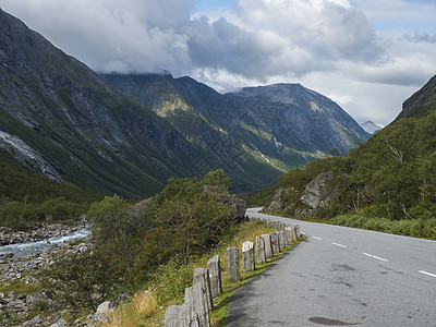 蜿蜒的道路与山地块 巨魔墙 位于挪威 Romsdal 山谷的 Rauma 河峡谷 蓝天白云 夏季公路旅行旅游风景图片