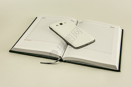 日记在白色背景和智能手机上写着背景图片