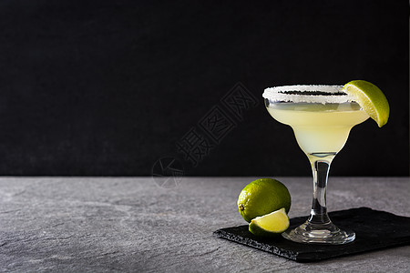 灰色背景的玛格丽塔鸡尾酒和玻璃中的石灰酒精食物饮料果汁派对热带绿色酒吧茶点图片