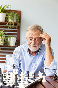 在家玩象棋的老年退休男子 在家中竞赛游戏数字房子竞争男人眼镜玩家思考闲暇图片