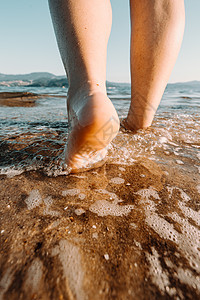 女人脚踏入西班牙海滩的海中图片