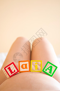 白露字腿肚子上写着laia字的孕妇男生立方体母性腹部母亲婴儿怀孕女孩背景