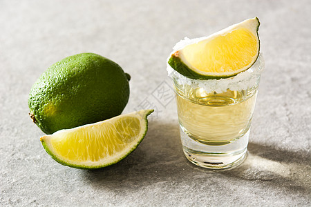 墨西哥的金龙舌兰加灰色背景的石灰和盐液体水果桌子酒精饮料金子玻璃图片