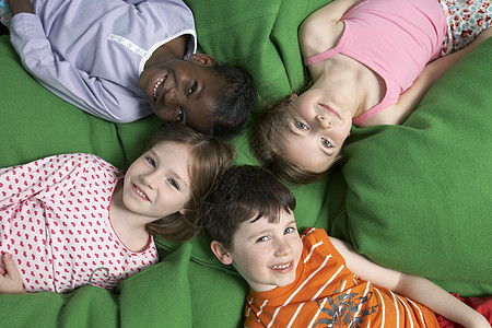 男孩和三个女孩(5至7岁)躺在背面图片