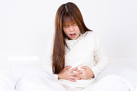 年轻妇女躺在床上胃痛 在医疗或日常生活概念上受到保健护理的治疗 第12条痛苦女士女孩经期长椅成人月经女性疾病肚子图片