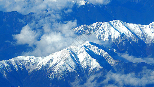 东藤山周围雪丘的顶角图像鸽子顶峰蓝色天空冰川全景爬坡道风景白色雪山图片