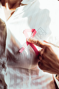 一个老女人用粉色丝带指着胸口治愈乳腺癌检测疾病帮助胸部健康生存世界女性图片