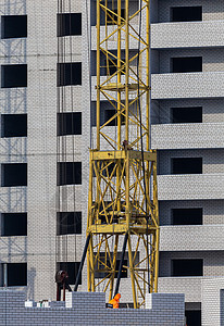 建筑工地 未完工的公寓楼 工人和起重机图片