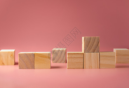 粉红色背景的木板立方体 要将新想法投入粉色木头静物平衡彩色教育笔记摄影桌子学习图片