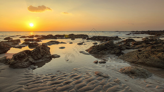 在低潮下显示沙状的金色日落光下的海滩上海岸地平线海景支撑天空波纹反射太阳海洋日落图片