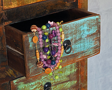 在旧油漆的木制抽屉里 紧贴着彩色珠宝首饰乡村装饰品剪纸木头珊瑚贮存风格胸部古董案件图片