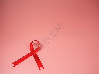 粉红色背景的红丝带 世界援助日概念 符号概念图片