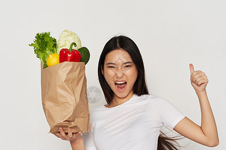 以一揽子食品和幸福妇女新鲜蔬菜为食物图片