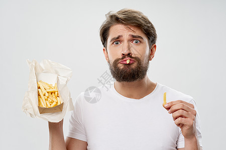 盒子里有马铃薯的男性 快餐卡路里图片