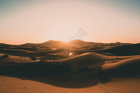 清晨日出光明中无人之光中的撒哈拉沙漠空沙丘图片