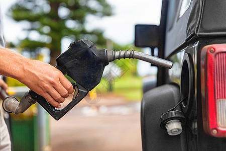 牧马人车素材加油站加油泵 有人在汽车内装满汽油燃料的喷嘴背景