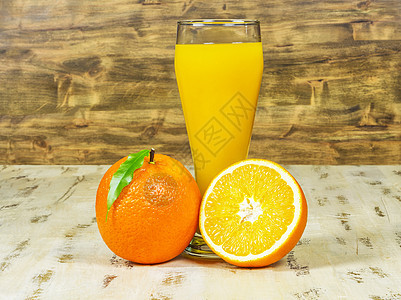 一杯新鲜橙汁和木本底橘子的杯子图片