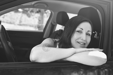 微笑的女人看着车 黑白相片图片