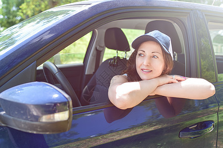 一个微笑着的女人的肖像 戴着帽子坐在车里 看一眼图片