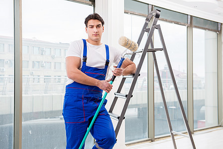 在建筑工地工作的油漆修理工工作服男性职业微笑绘画贸易滚筒梯子房间工具图片