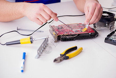 由有经验的技术员修理计算机硬件和固定概念以及安装工作木板修理工打扫芯片螺丝刀焊接电路镊子图片