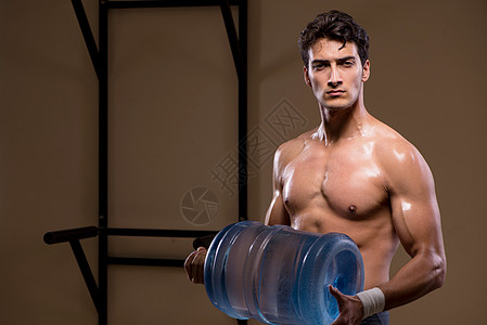 使用大水瓶的肌肉撕裂人力量锻炼瓶子运动俱乐部活动举重培训师训练运动员图片