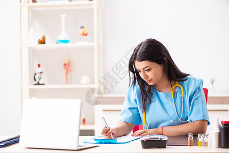 在诊所工作的年轻 美丽的女医生在诊所工作案件治疗师实习生咨询医院保险医师临床药剂师写作图片
