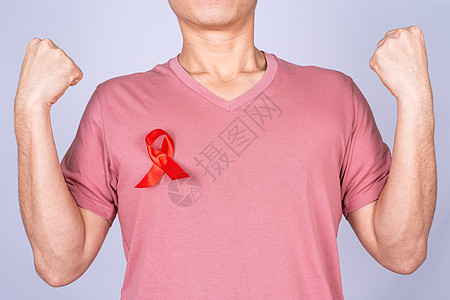 男人胸前的红色艾滋病意识丝带 举起手在灰色背景下与他们作斗争 世界艾滋病日 医疗保健和医疗概念癌症性别活动丝绸插图疾病幸存者预防图片