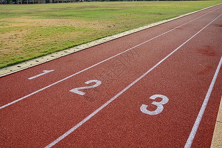 红色跑步车 在体育场用绿色草地赛道白色场地赛跑者车道数字赛马场运动竞争竞赛橡皮图片