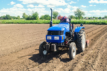 拖拉机上的农民用铣刨设备松土 疏松地表 开垦土地 农业 农业 犁田 农机具使用工作要简化和加快图片