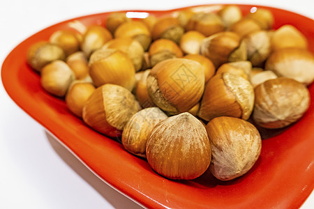 红盘上带心脏数的贝壳栗子巧克力食物小吃种子营养宏观坚果团体小路甜点图片