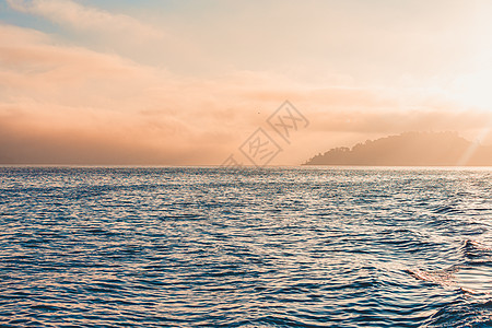 巨大的海平面 山峰和烟雾在背景图片