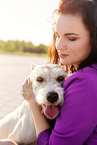有魅力的年轻女子在公园里拥抱她的狗爪子训练幸福快乐动物伴侣成人混种女士犬类图片