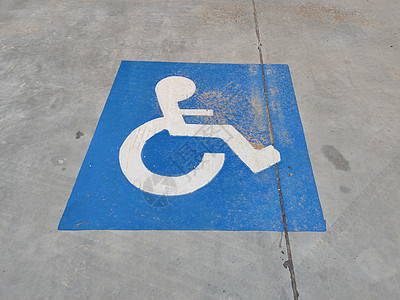 柏油沥青上关于残疾人停车的蓝色标志图片