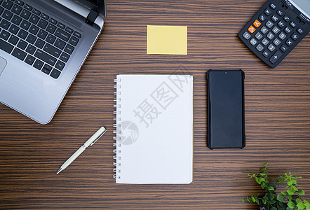 办公桌工作环境 棕色条纹斑马木设计桌面上的记事本 便签 笔杆 计算器和膝上型电脑 在 Covid19 期间在家工作时必须有物品键图片