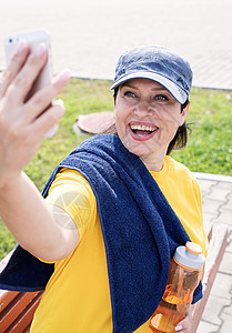 微笑的高级女运动员在公园户外自拍活动女士女性退休电话成人娱乐健康训练锻炼图片
