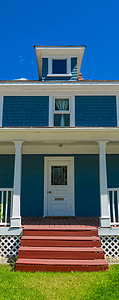 住家入口处 前方和蓝天空背景有门台阶邻里财产住房栏杆社区门廊窗户建筑住宅房子图片