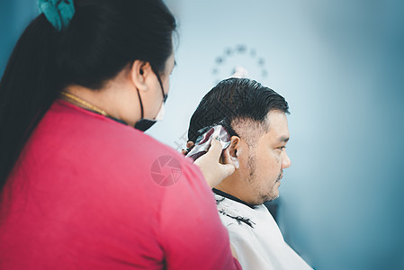 理发店的发型或理发师理发顾客椅子剪刀沙龙男人男性梳子头发潮人店铺发型师图片