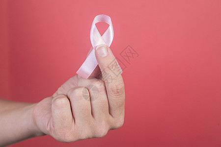 癌症预防女人手上的粉红丝带有粉红色背景治疗保健活动幸存者女孩女性帮助医疗胸部预防背景