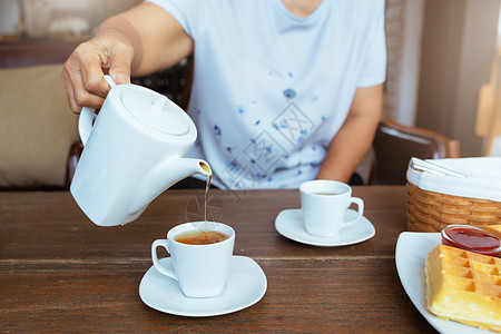 木桌上泡茶的女性风景杯子饮料茶壶早餐玻璃陶器咖啡店桌子茶点肉桂图片