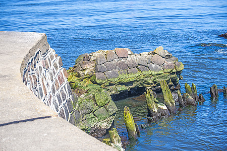 以旧石块和第二次世界大战墙壁的乌斯特卡Ustka海港石头码头巨人海洋废墟遗迹港口图片