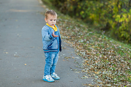 一个站在城市公园小路上的小男孩图片