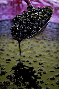 波斯尼亚巧克力莓浆 在一锅加满了窒息莓果酱的罐子上方的卷轴里背景