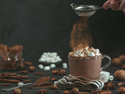热可可肉桂粉和热巧克力在玻璃杯上飘扬早餐美食液体厨房可可巧克力桌子飞行杯子季节背景
