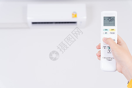 人手正在使用空调的白色遥控器打开或调节室内空调的温度气候房间呼吸机力量扇子技术活力房子通风器具图片