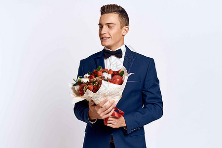 一个穿着经典西装的优雅男子 领领结领带 手里握着一束花束丈夫男性花朵纪念日礼物玫瑰周年男朋友套装展示图片