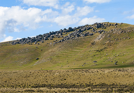 新西兰的山丘高地城堡地区远足巨石高山路线蓝色滚动草原曲线山脉晴天图片