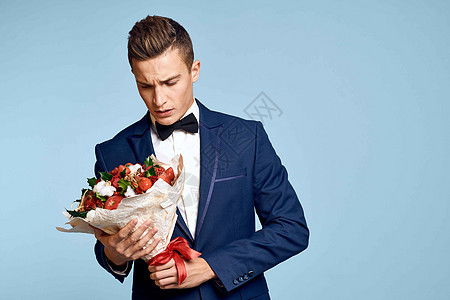 浪漫男人 有一束花朵和领结 在蓝色背景的风景下商务男性成人丈夫周年展示花束人士惊喜生日图片