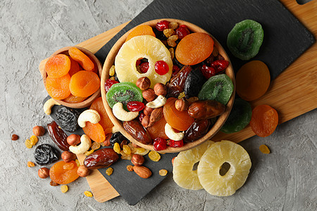 灰色的 有干果和坚果的碗木板李子水果营养小吃桌子食物菠萝榛子饮食图片
