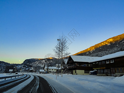 日出时驾车穿过挪威的山村阳光街道村庄旅游农村公路极夜太阳景观旅行图片